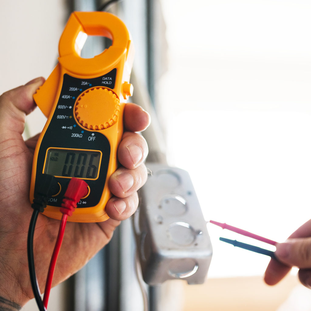 main qui tient un appareil de tension électrique vallée électricité votre partenaire électricien en gironde nouvelle aquitaine france