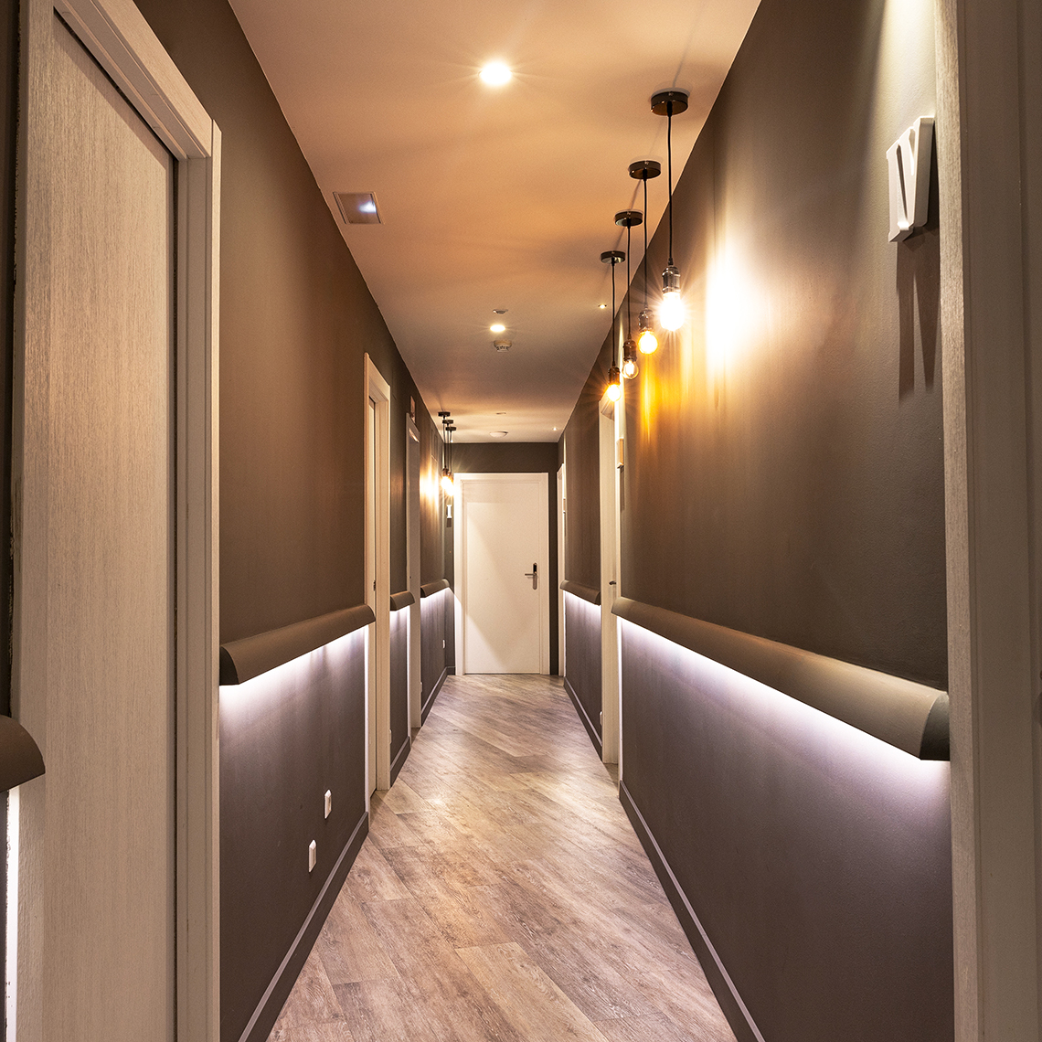 couloir hôtel de luxe beige et marron clair avec suspension lumineuse vallée électricité votre partenaire électricien en gironde nouvelle aquitaine france